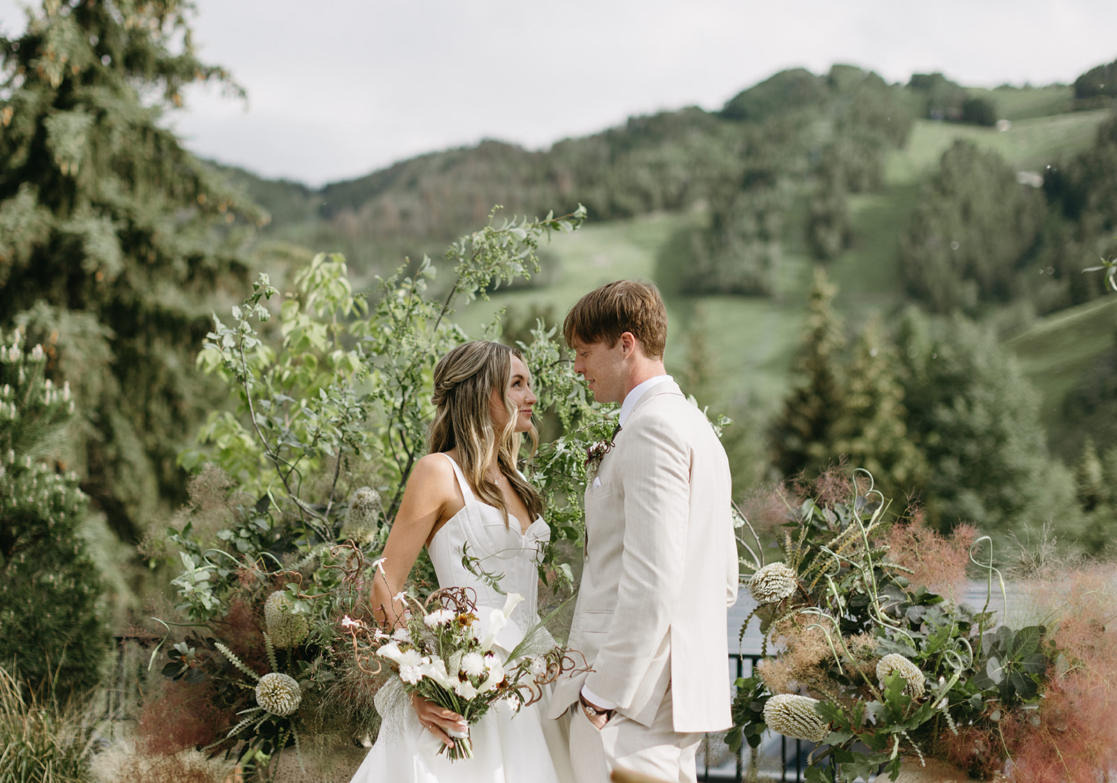 Bride and groom stand in front of Aspen mountain on the MOLLIE rooftop.